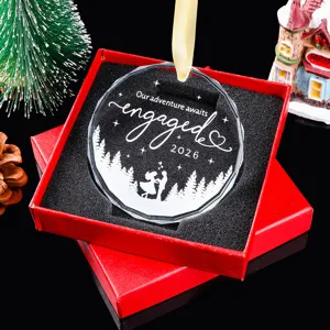 Detailweergave van de gegraveerde kerstversiering 'Engaged 2026' in een rode geschenkdoos