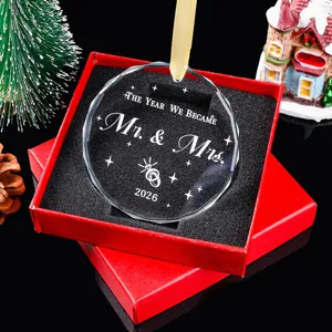 Detail van gegraveerd kristallen kerstornament Mr. & Mrs. 2026 in rode geschenkdoos