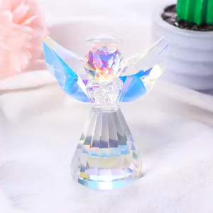 Vista detallada de una figurita de ángel de cristal con alas de arco iris irisadas