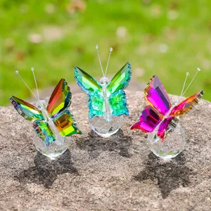 Detailed view of three colorful faceted crystal butterfly ornaments on a natural stone