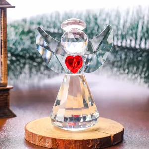 Vista detallada de una figurita de ángel de cristal facetado con un corazón rojo