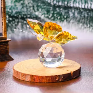 Detailed macro view of a yellow crystal butterfly perched on a faceted crystal glass ball.