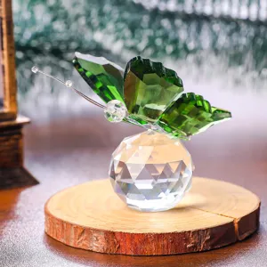 Detailed view of a green crystal butterfly perched on a faceted crystal base.