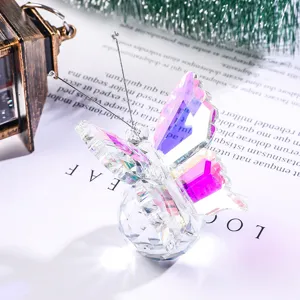 Macro di una statuina di farfalla in cristallo con riflessi rosa e viola cangianti.