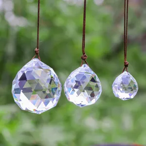 Detailed view of faceted K9 crystal ball suncatchers in three sizes with rainbow reflections