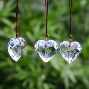 Close-up of three faceted heart crystal suncatchers hanging outdoors