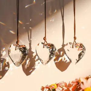 Detailed macro view of heart-shaped K9 crystal prisms reflecting rainbow sunlight refractions.