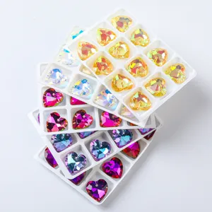 Multi-colored heart-shaped crystal pendants arranged neatly in a white storage tray.