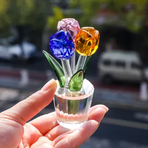 Primer plano de un adorno de tulipán de cristal de colores facetado en la mano