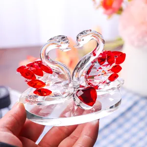 Close-up of a couple crystal swans with red heart for wedding gift decor