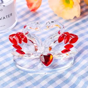 Close-up of elegant crystal swan pair with red heart and faceted wing details
