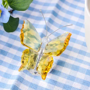 Detailed close-up of a yellow faceted crystal butterfly figurine on blue checkered cloth
