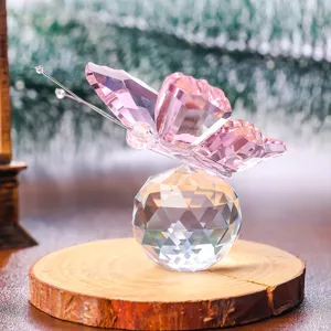 Exquisite pink faceted crystal butterfly perched on a sparkling crystal ball base.