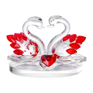 Detailed view of elegant crystal swan figurine with red heart and faceted wings decoration.