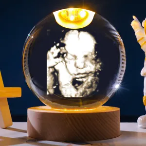 Gedetailleerd macrobeeld van kristallen bol nachtlampje met 3D baby echografie gravure