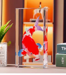 Gros plan d'un poisson koi gravé au laser en 3D dans un bloc de cristal clair.
