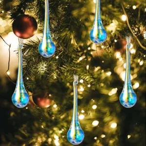 Adornos navideños en forma de lágrima iridiscente colgados en un árbol festivo con luces