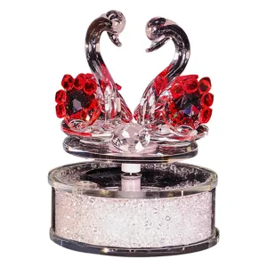 Elegant crystal swan pair ornament with red flowers for car and home decor.