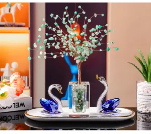 Detail of K9 blue crystal swans and a green gemstone money tree on a tray for home decor