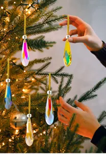 Detailed view of colorful iridescent crystal teardrop ornaments on a lit Christmas tree