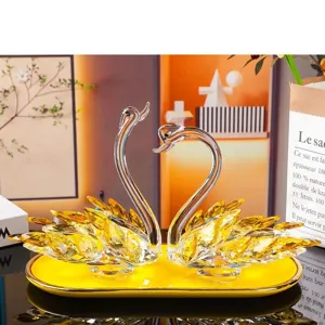 Elegant pair of crystal swan figurines on a yellow decorative tray for home and office decor