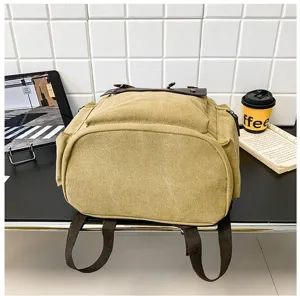 Detalle de la base reforzada de una mochila de lona caqui vintage para estudiantes