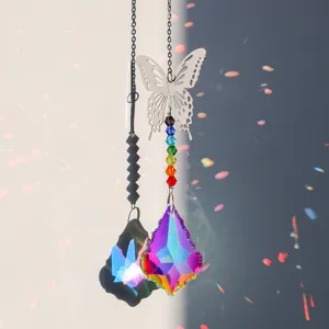 Makroansicht Sonnenfänger Kristall mit Metallschmetterling und Regenbogen-Lichteffekt