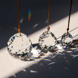 Close-up of three K9 faceted crystal ball suncatchers creating rainbow light reflections.
