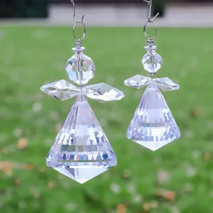 Primer plano de atrapasoles de cristal facetado con forma de ángel en un jardín exterior