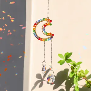 Detailed view of a moon-shaped crystal suncatcher with rainbow reflections in sunlight