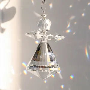 Detalle de atrapasol de ángel de cristal facetado que refleja arcoíris vibrantes en la pared