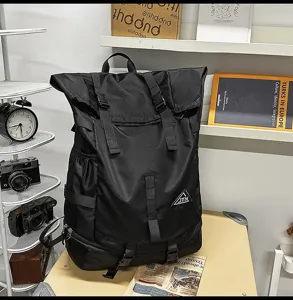 Seitenansicht des schwarzen Roll-Top-Outdoor-Rucksacks mit JTN-Logo und Schnallen