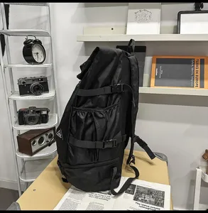 Seitenansicht des großen schwarzen Roll-Top-Rucksacks mit Seitenschnallen und Taschen