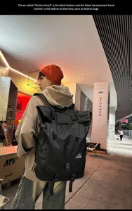 Detail eines großen schwarzen Roll-Top-Rucksacks, getragen für Reisen oder Sport.