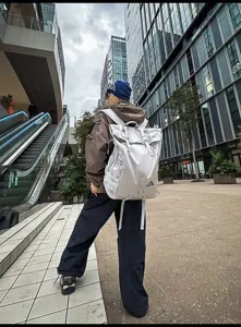 Großer grauer Roll-Top-Outdoor-Sportrucksack mit separatem Schuhfach in städtischer Umgebung