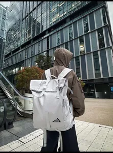 Großer grauer Roll-Top-Rucksack an einer Person im urbanen Stil für Outdoor-Reisen