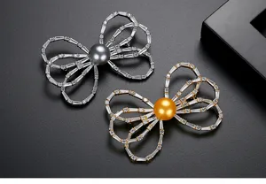 Elegant bowknot brooches detailed with shimmering shell pearls and sparkling zircons.