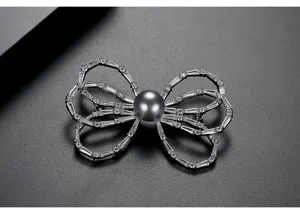 Detailed macro view of an elegant bow brooch featuring sparkling stones and a dark shell pearl