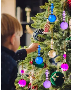 Detail van prachtige gekleurde kristallen ornamenten hangend aan een groene kerstboom