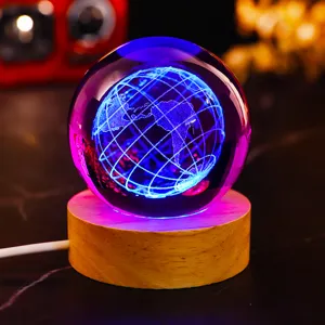 Detailed view of 3D laser engraved earth within a crystal ball night light on wooden base