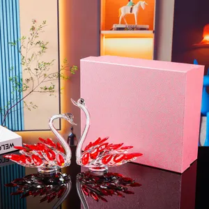 Elegant crystal swan couple figurines with red accents and pink gift box for home decor.
