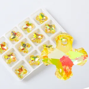 Primer plano detallado de colgantes de cruz de cristal amarillo aurora AB para joyería DIY.