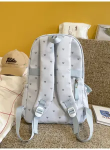 Detailed back view of light blue backpack with silver heart pattern and adjustable straps