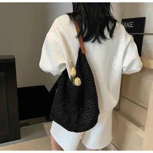 Detailed back view of model wearing a black hollow knit mesh shoulder bag with tulip decor