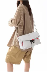 Vista lateral que muestra el ajuste y detalle de una bolsa de mensajero techwear cruzada al hombro