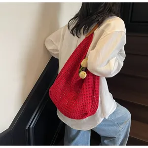 Detailed view of the red hollow mesh knit bag with a textured crochet pattern and strap