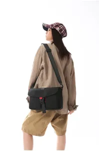 Modelo con un bolso bandolera techwear negro con hebilla utilitaria y correa ajustable