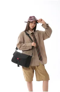 Vista detallada de una bolsa de mensajero negra techwear usada por una modelo en estilo workwear