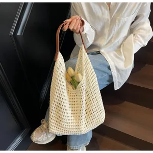 Detailed view of cream knit mesh tote bag with brown handle in a lifestyle setting