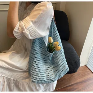 Detail view of a light blue hollow mesh crochet shoulder bag with floral accents